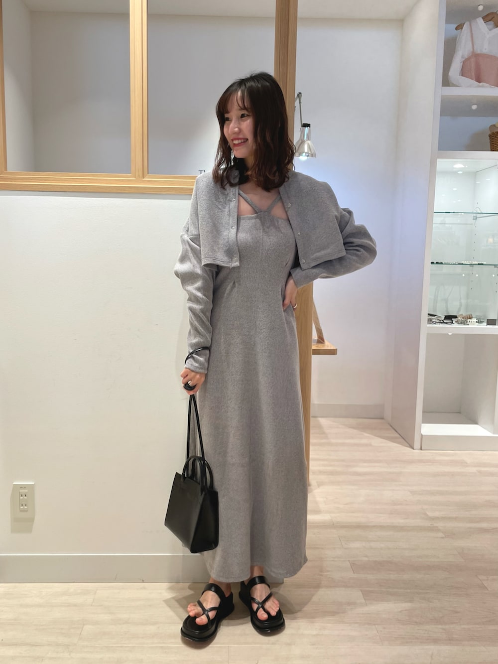 ブラック系のワンピース、ブラック系のトートバッグ、ブラック系のサンダルを着用したレディースの春コーディネートの4枚目の写真