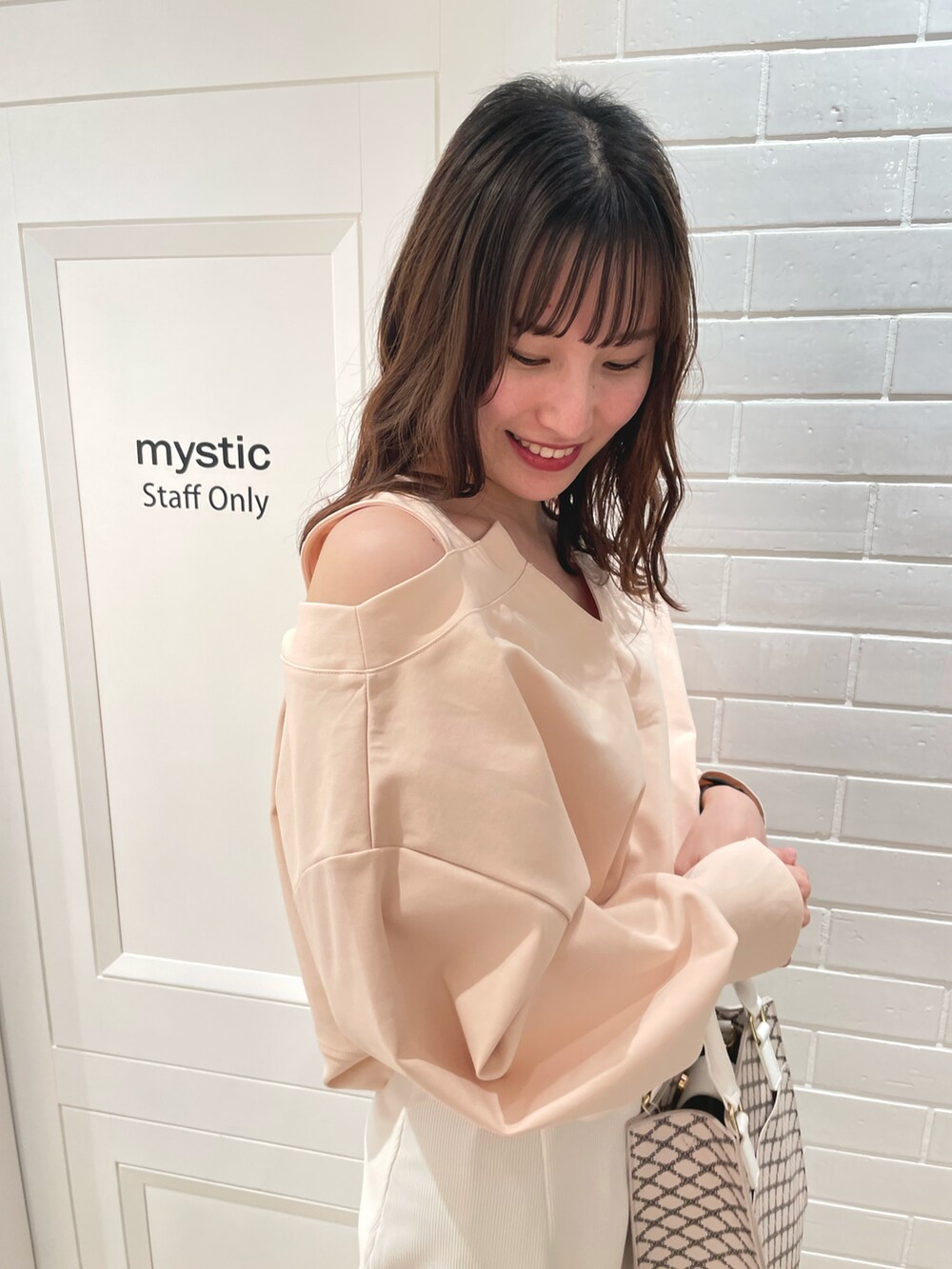 ホワイト系のその他トップス、ホワイト系のスカート、ベージュ系のショルダーバッグを着用したレディースの春コーディネートの2枚目の写真