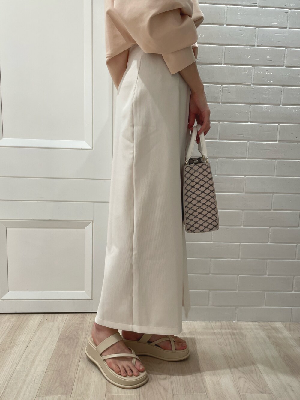 ホワイト系のその他トップス、ホワイト系のスカート、ベージュ系のショルダーバッグを着用したレディースの春コーディネートの3枚目の写真