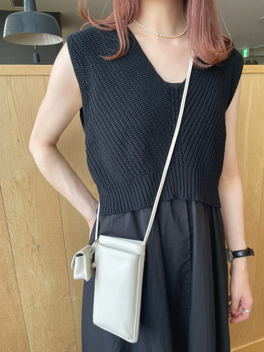 ブラック系のワンピース、ホワイト系のショルダーバッグ、ホワイト系のスリッポンを着用したレディースの夏コーディネートの2枚目の写真