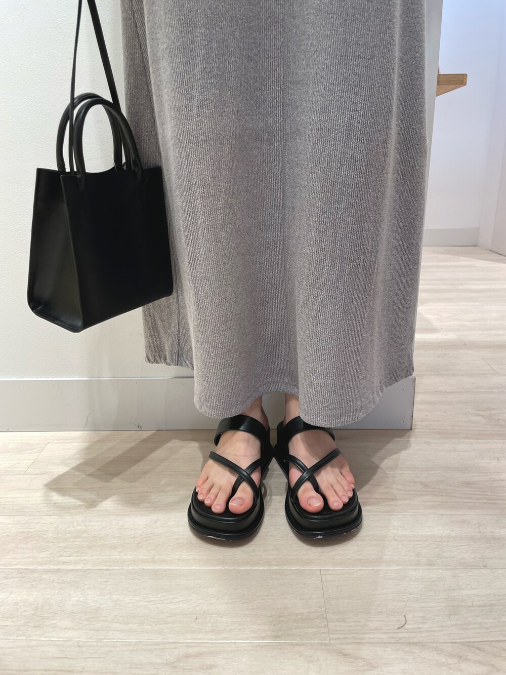 ブラック系のワンピース、ブラック系のトートバッグ、ブラック系のサンダルを着用したレディースの春コーディネートの3枚目の写真