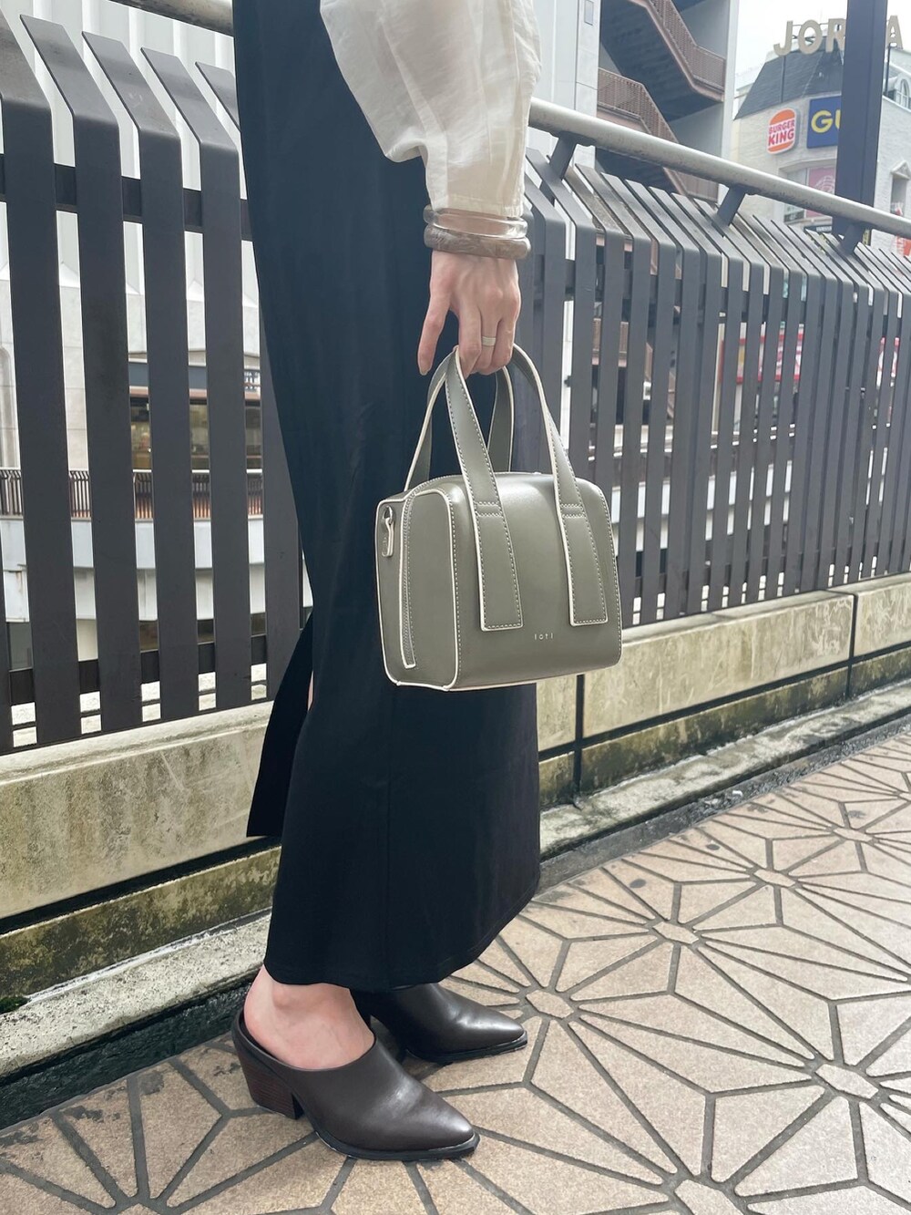 ホワイト系のシャツ/ブラウス、ブラック系のワンピース、グリーン系のボストンバッグを着用したレディースの秋コーディネートの2枚目の写真