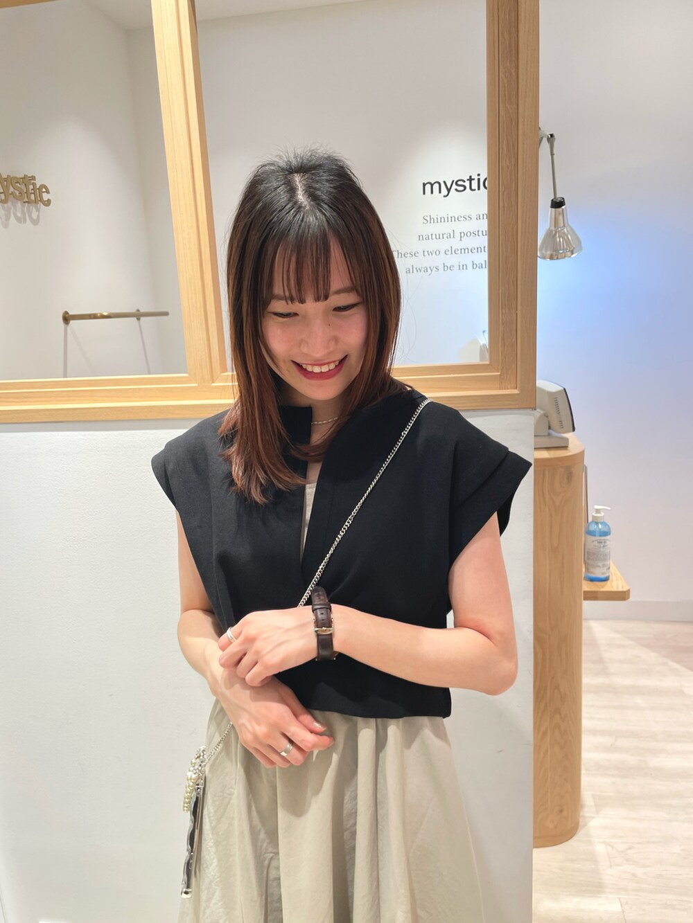 ベージュ系のワンピース、ホワイト系のサンダル、シルバー系のスマホケース/カバーを着用したレディースの春コーディネートの4枚目の写真