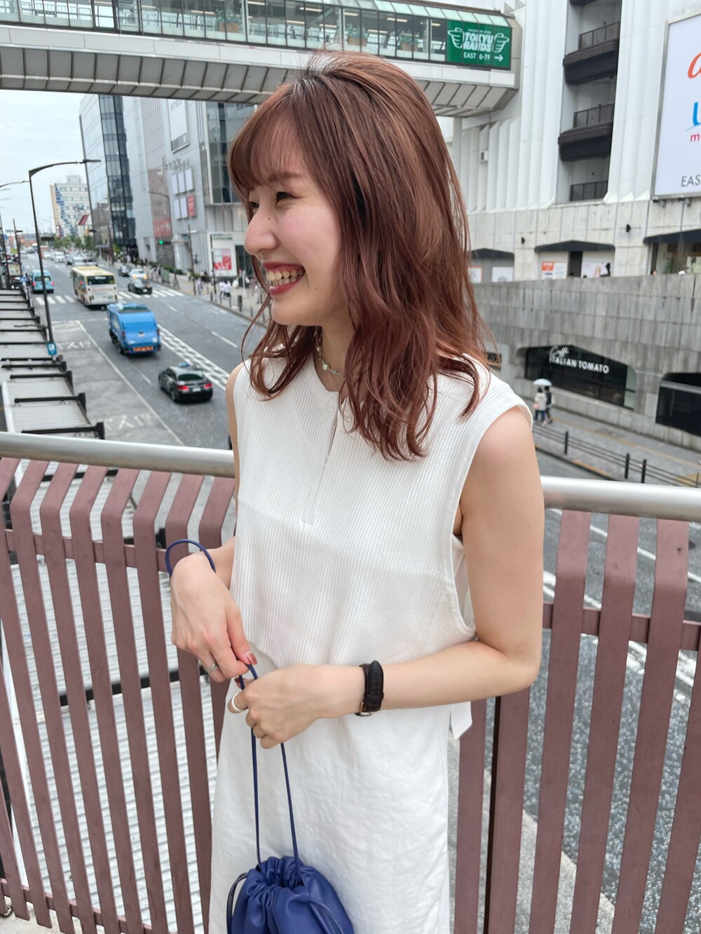 ホワイト系のワンピース、ブルー系のショルダーバッグ、ホワイト系のスリッポンを着用したレディースの夏コーディネートの2枚目の写真