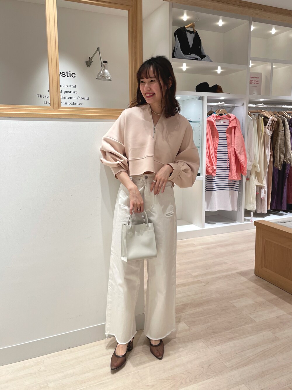 ベージュ系のTシャツ/カットソー、ホワイト系のデニムパンツ、ホワイト系のトートバッグを着用したレディースの春コーディネートの5枚目の写真