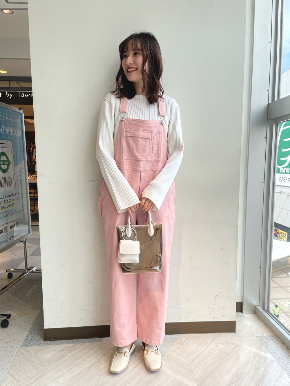 ホワイト系のニット/セーター、ピンク系のサロペット/オーバーオール、ホワイト系のショルダーバッグを着用したレディースの春コーディネートの2枚目の写真