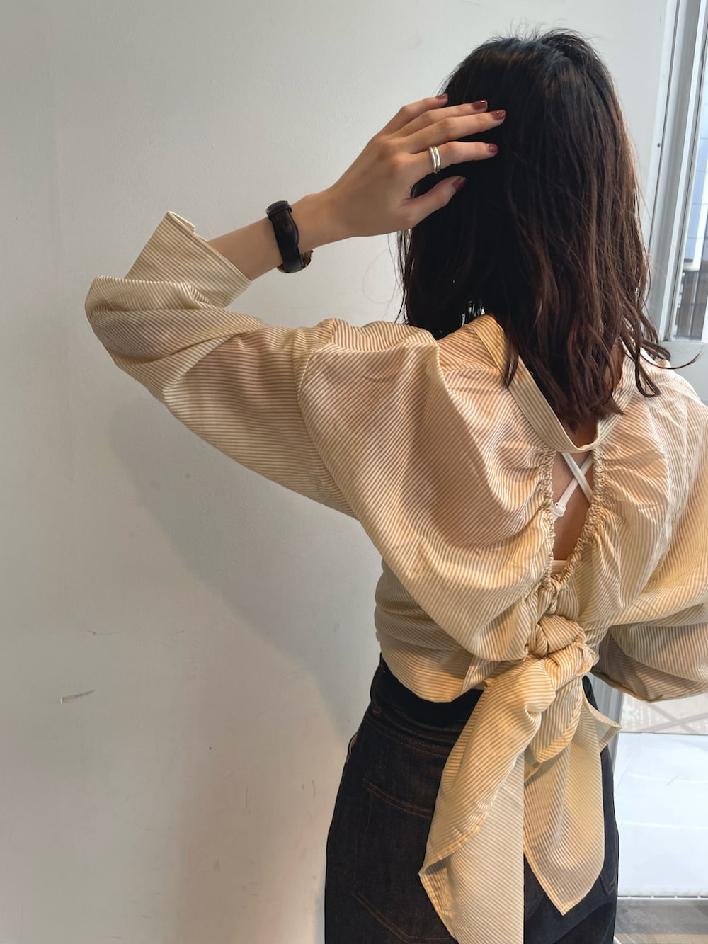 イエロー系のシャツ/ブラウス、ブルー系のデニムパンツ、シルバー系のサンダルを着用したレディースの春コーディネートの3枚目の写真