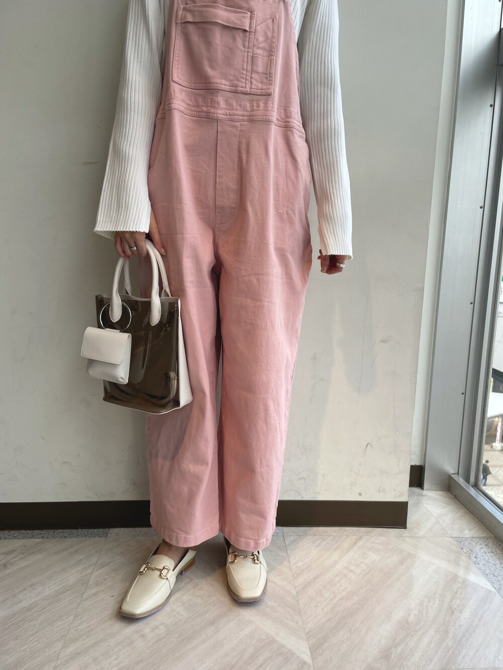 ホワイト系のニット/セーター、ピンク系のサロペット/オーバーオール、ホワイト系のショルダーバッグを着用したレディースの春コーディネートの4枚目の写真