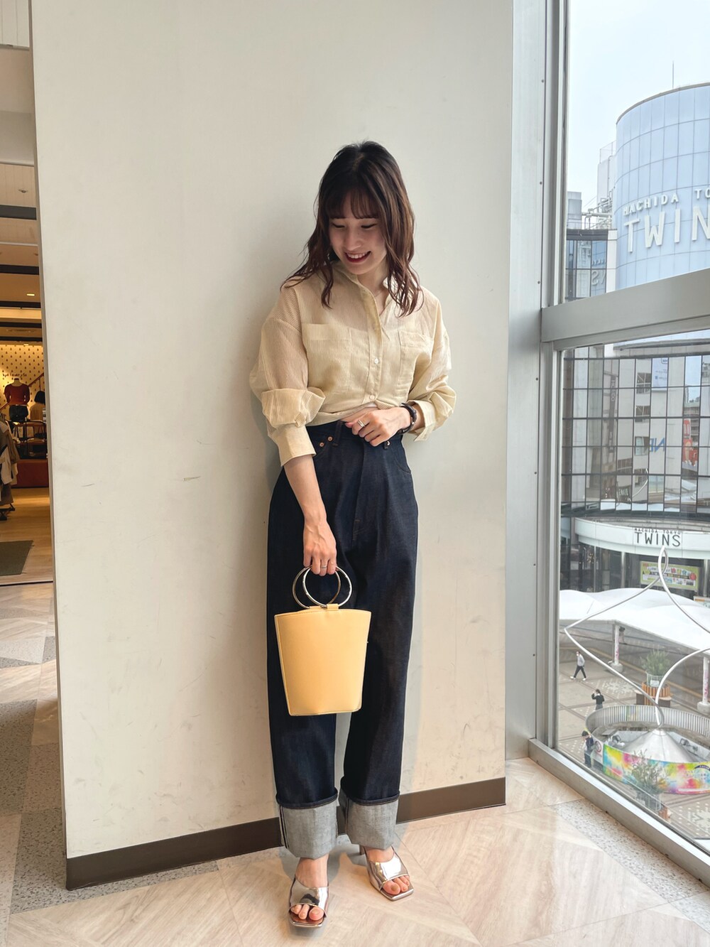 イエロー系のシャツ/ブラウス、ブルー系のデニムパンツ、シルバー系のサンダルを着用したレディースの春コーディネートの4枚目の写真