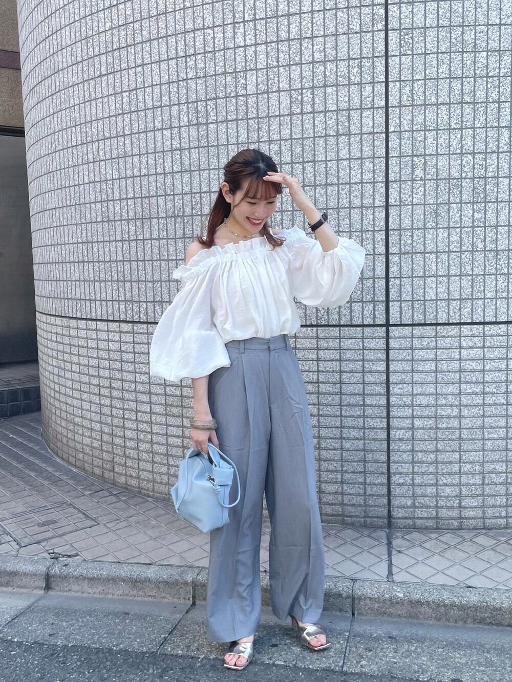ホワイト系のシャツ/ブラウス、グレー系のスラックス、ブルー系のショルダーバッグを着用したレディースの夏コーディネートの3枚目の写真