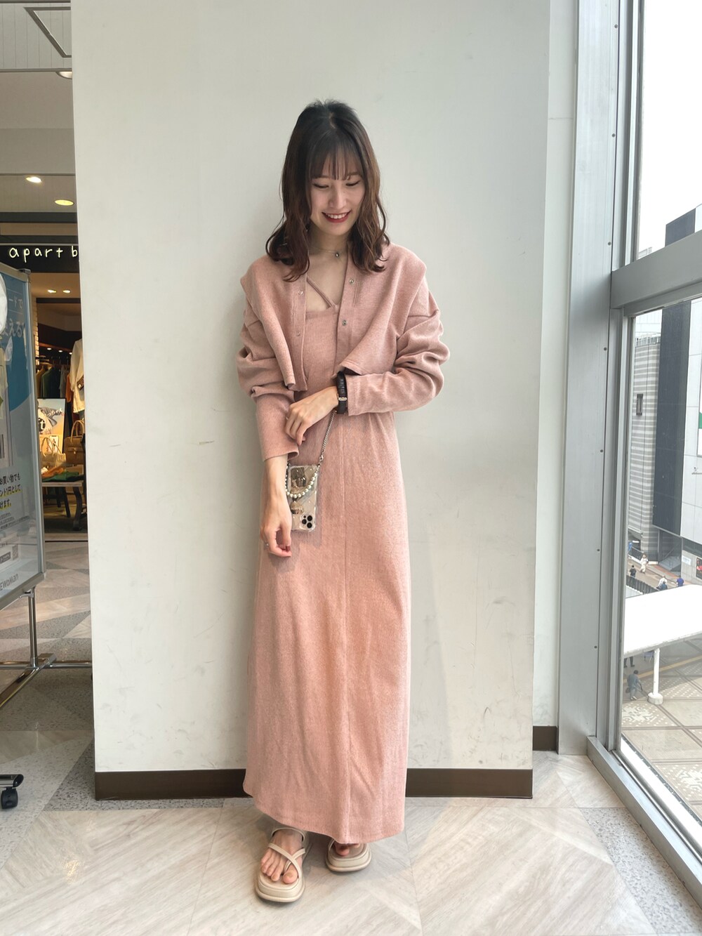 オレンジ系のワンピース、ホワイト系のサンダル、その他のスマホケース/カバーを着用したレディースの春コーディネートの3枚目の写真