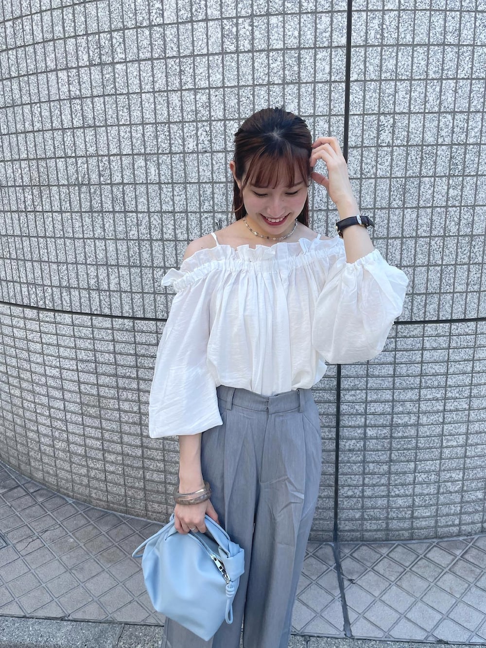 ホワイト系のシャツ/ブラウス、グレー系のスラックス、ブルー系のショルダーバッグを着用したレディースの夏コーディネートの2枚目の写真