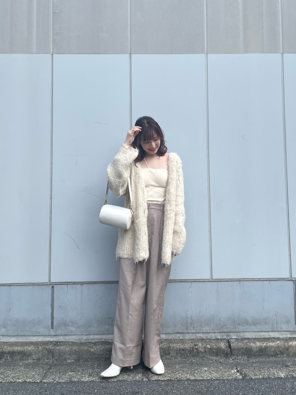 ベージュ系のカーディガン/ボレロ、ベージュ系のスラックス、ホワイト系のショルダーバッグを着用したレディースの夏コーディネートの2枚目の写真