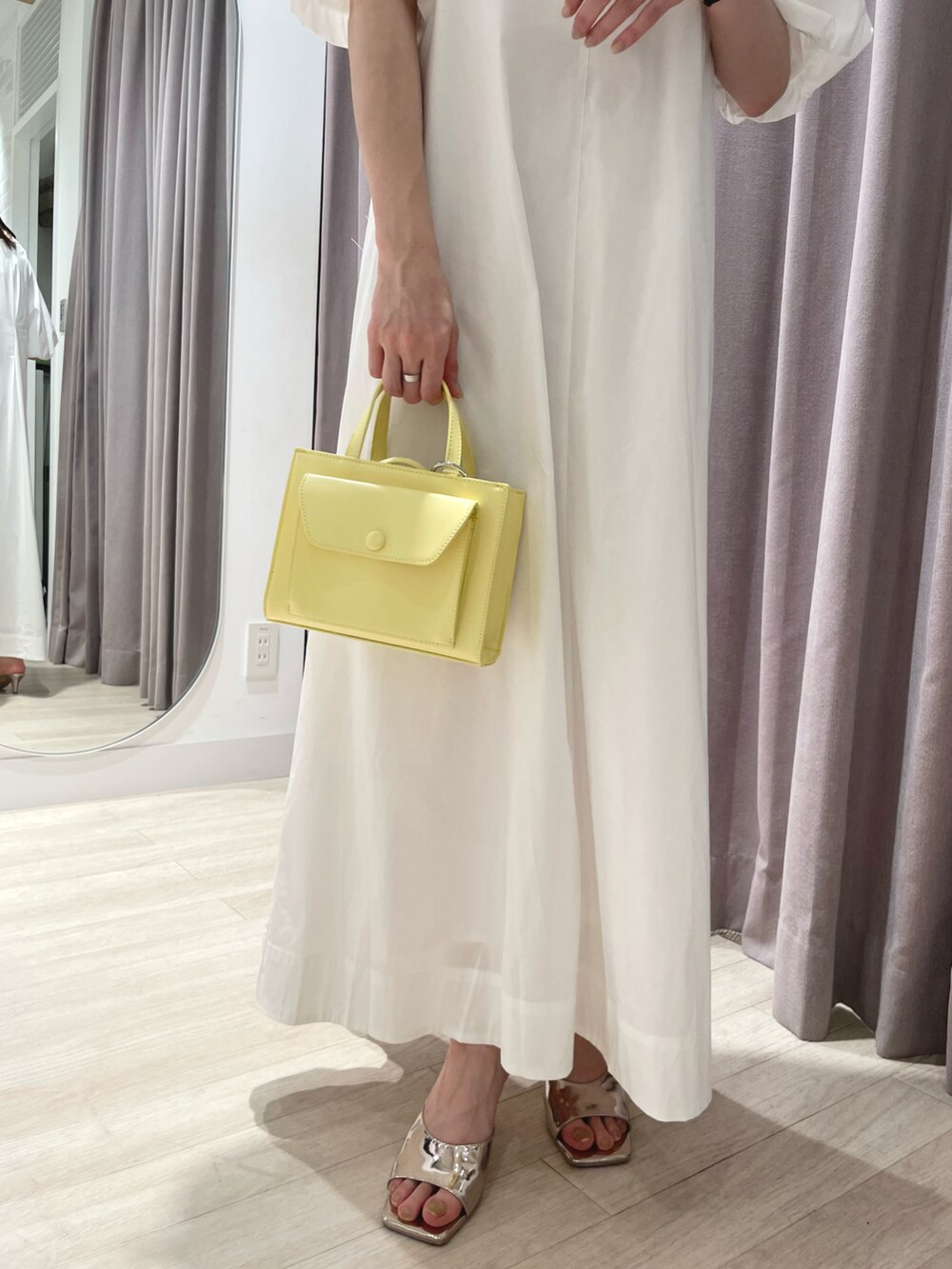 ホワイト系のワンピース、イエロー系のショルダーバッグ、シルバー系のサンダルを着用したレディースの春コーディネートの3枚目の写真