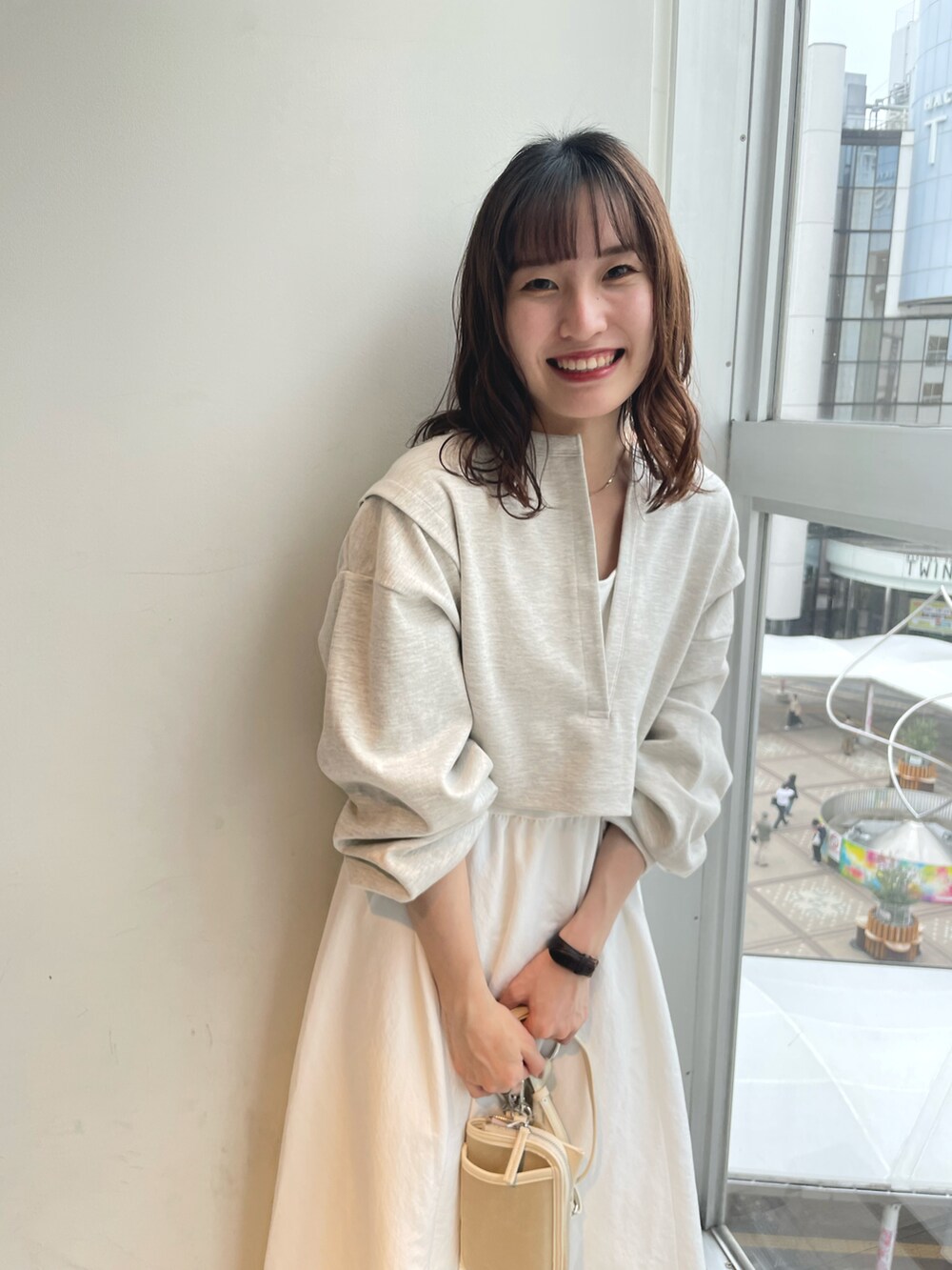 ホワイト系のワンピース、ベージュ系のショルダーバッグ、ブラウン系のサンダルを着用したレディースの春コーディネートの2枚目の写真