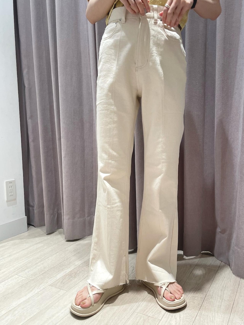 イエロー系のシャツ/ブラウス、ホワイト系のデニムパンツ、ホワイト系のサンダルを着用したレディースの春コーディネートの2枚目の写真