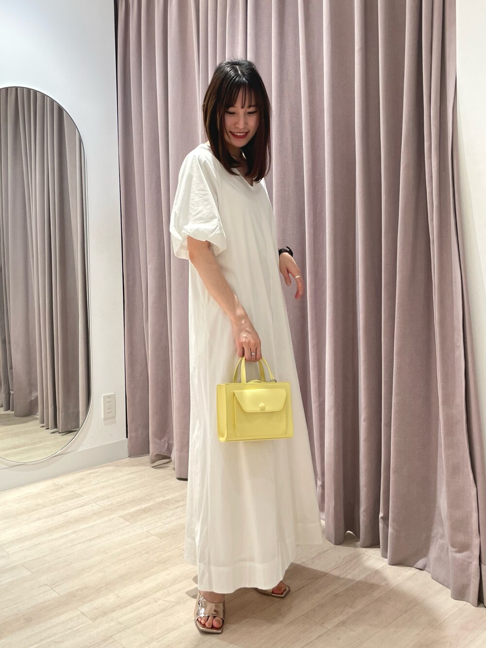 ホワイト系のワンピース、イエロー系のショルダーバッグ、シルバー系のサンダルを着用したレディースの春コーディネートの4枚目の写真