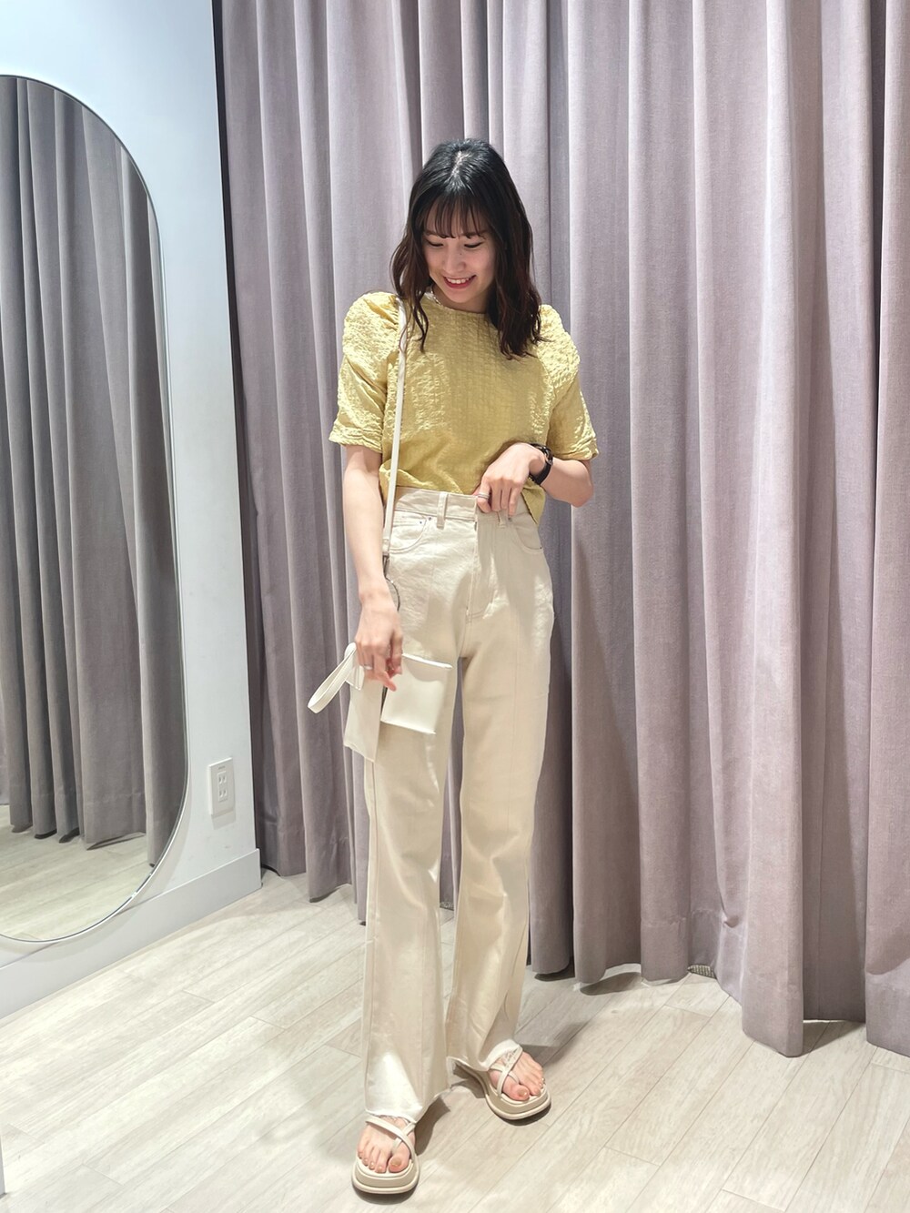 イエロー系のシャツ/ブラウス、ホワイト系のデニムパンツ、ホワイト系のサンダルを着用したレディースの春コーディネートの3枚目の写真