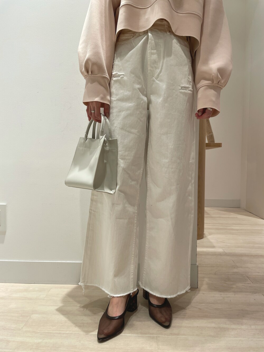 ベージュ系のTシャツ/カットソー、ホワイト系のデニムパンツ、ホワイト系のトートバッグを着用したレディースの春コーディネートの4枚目の写真