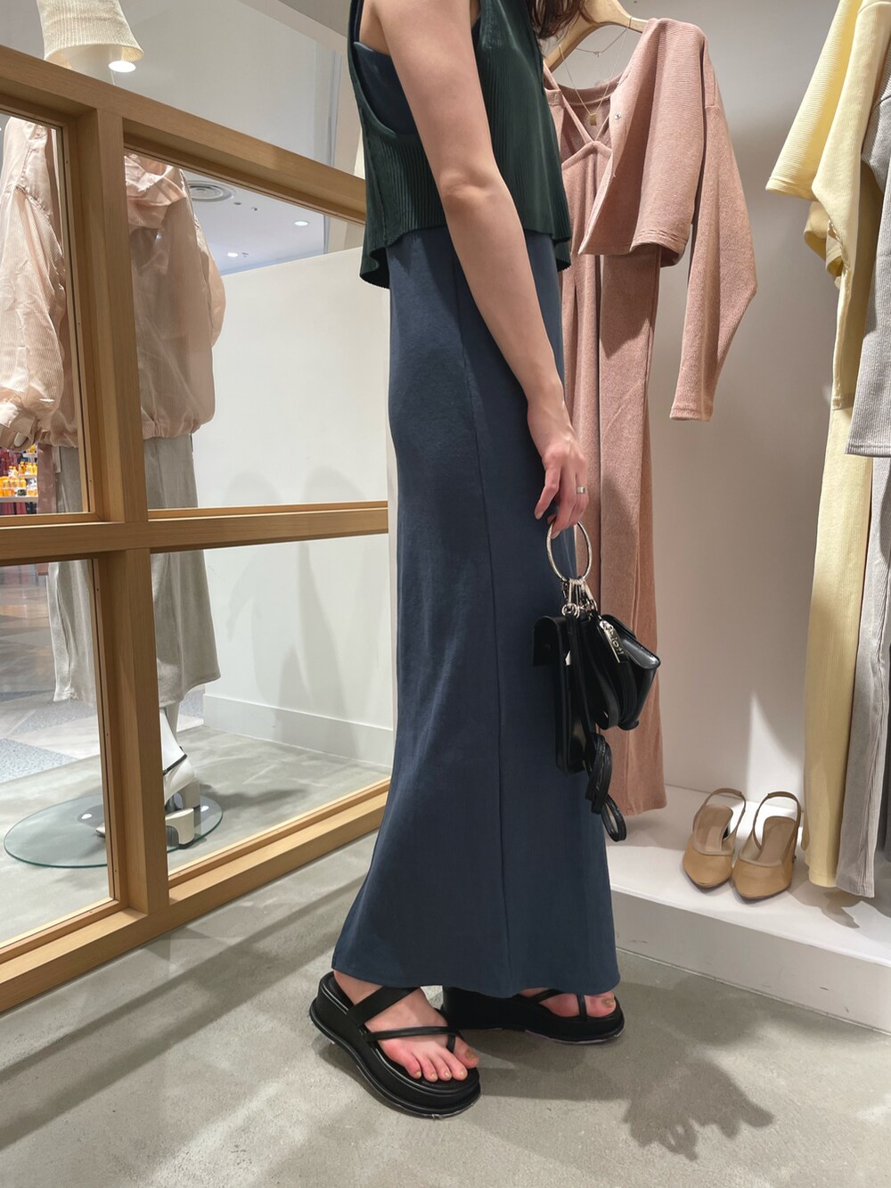 グリーン系のワンピース、ブラック系のショルダーバッグ、ブラック系のサンダルを着用したレディースの春コーディネートの3枚目の写真