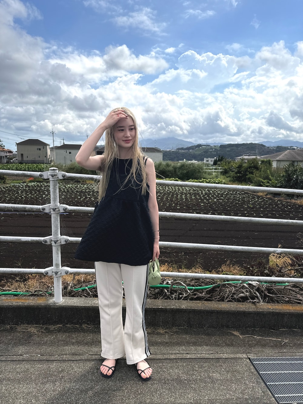 ホワイト系のその他パンツ、ブラック系のキャミソール、グリーン系のショルダーバッグを着用したレディースの夏コーディネートの2枚目の写真