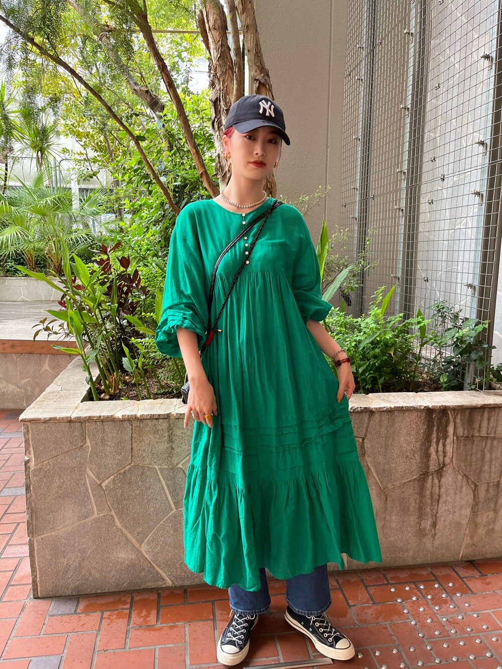 グリーン系のワンピースを着用したレディースの春コーディネートの2枚目の写真