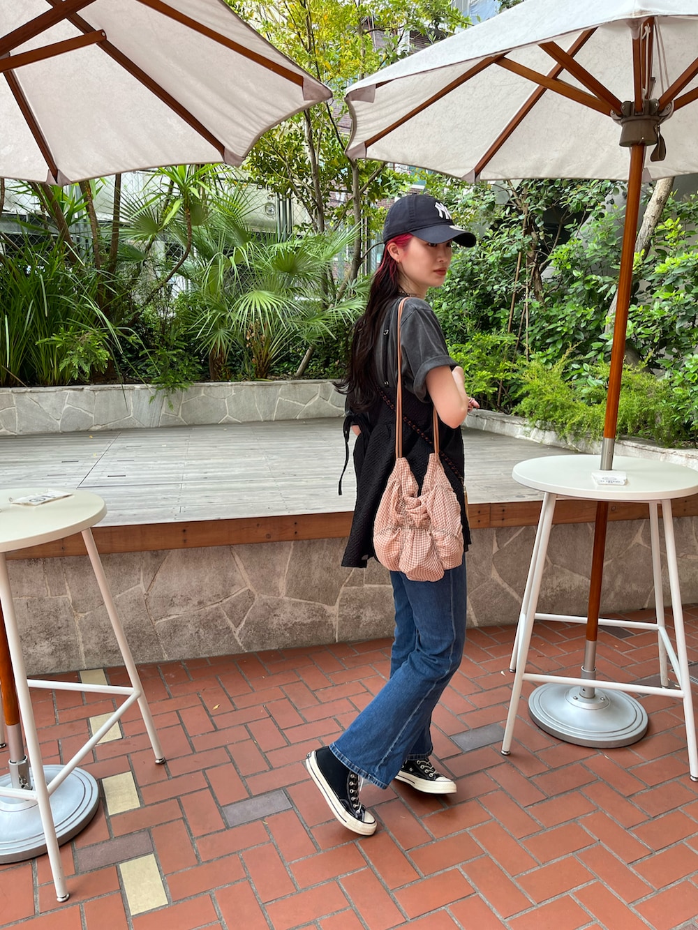 ブラック系のキャミソール、ブルー系のデニムパンツを着用したレディースの夏コーディネートの3枚目の写真