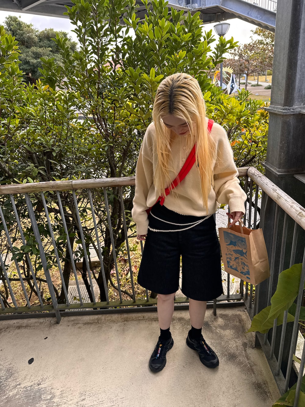 ベージュ系のニット/セーター、ブラック系のパンツ、ブラック系のスニーカーを着用したレディースの冬コーディネートの2枚目の写真