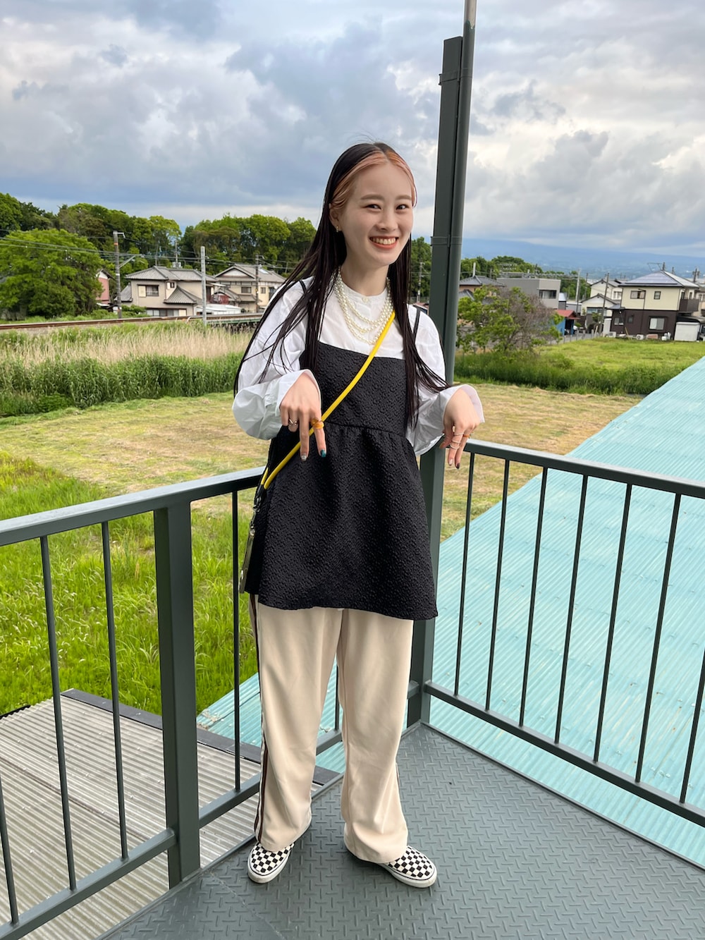 ブラック系のキャミソールを着用したレディースの春コーディネートの2枚目の写真