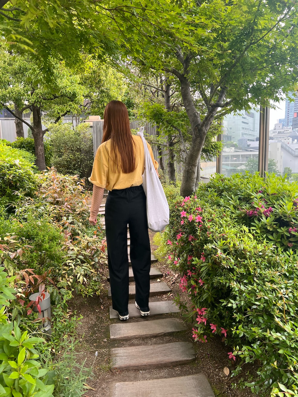 ブラック系のその他パンツ、ベージュ系のTシャツ/カットソー、イエロー系のTシャツ/カットソーを着用したレディースの春コーディネートの3枚目の写真