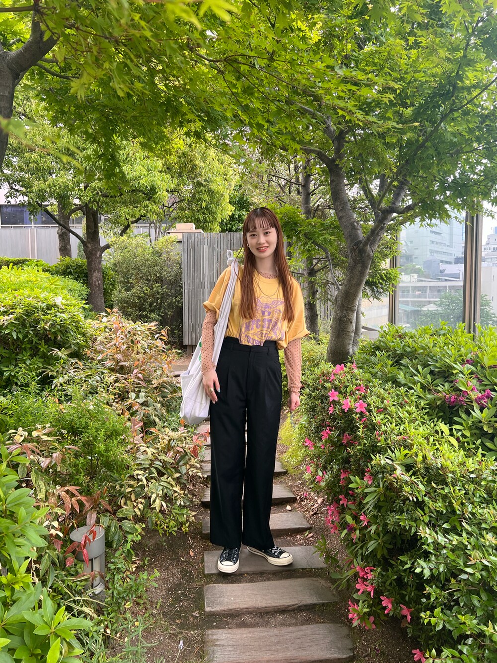 ブラック系のその他パンツ、ベージュ系のTシャツ/カットソー、イエロー系のTシャツ/カットソーを着用したレディースの春コーディネートの2枚目の写真