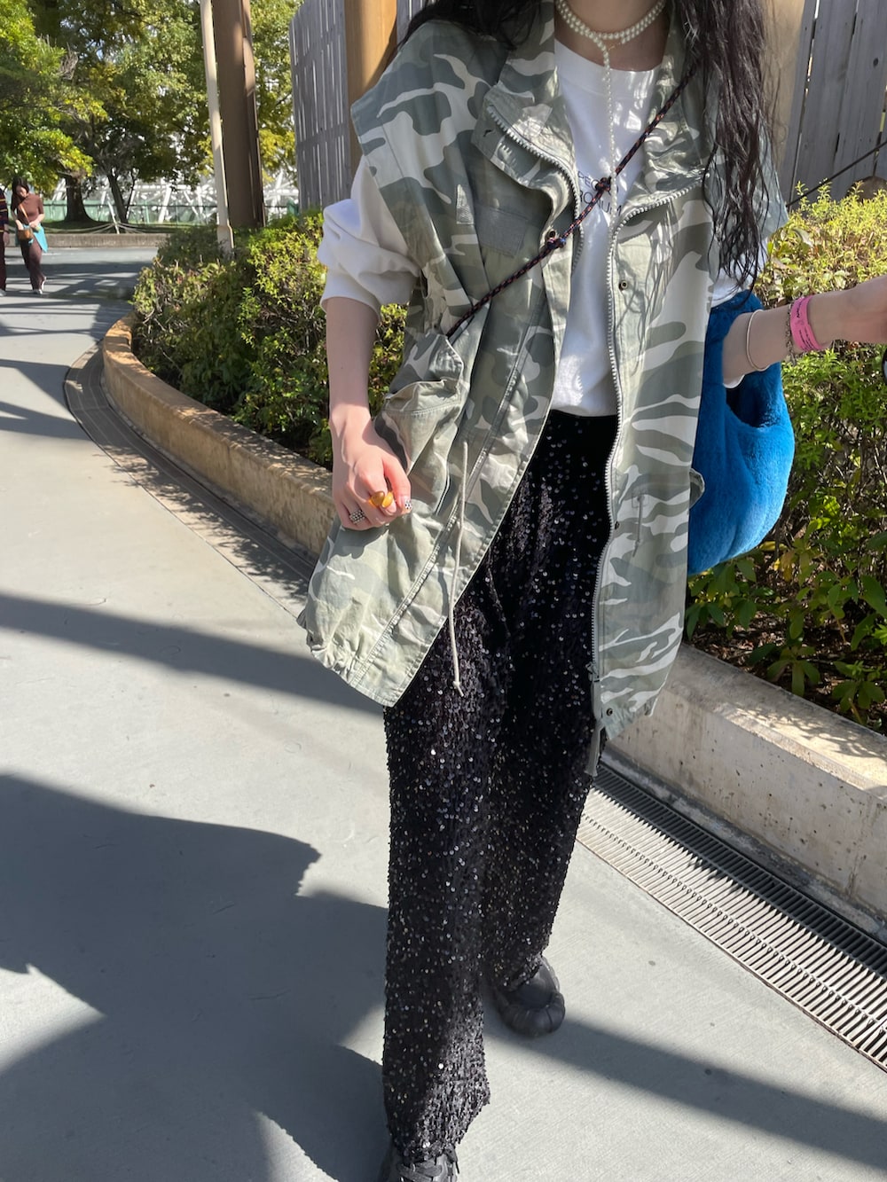 ブラック系のパンツ、グリーン系のミリタリージャケット、ブラック系のスニーカーを着用したレディースの秋コーディネートの3枚目の写真