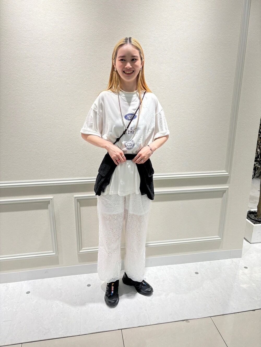 ブラック系のスニーカー、ホワイト系のTシャツ/カットソー、ブラック系のベルトを着用したレディースの秋コーディネートの2枚目の写真