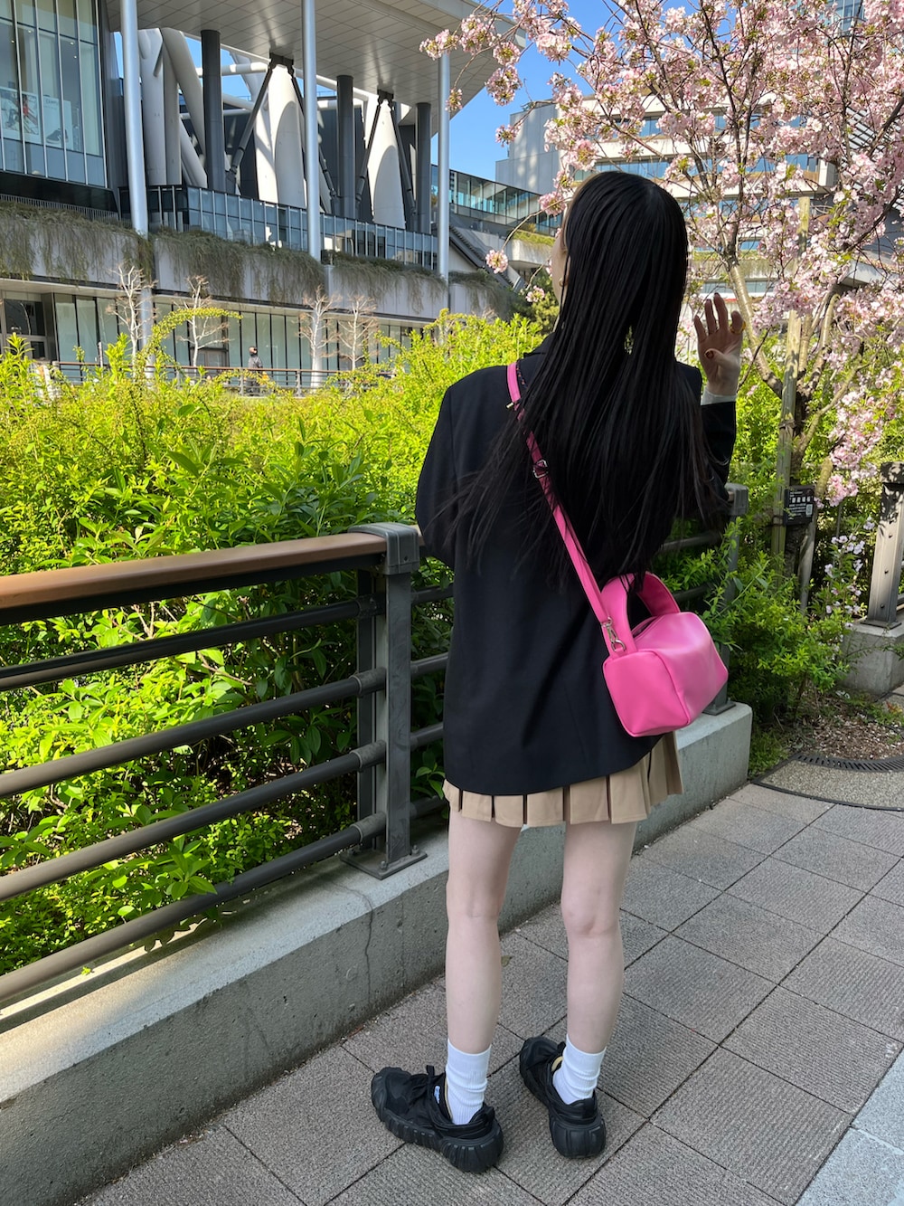 ブラック系のジャケット/アウター、グレー系のタンクトップ、ブラウン系のスカートを着用したレディースの春コーディネートの2枚目の写真