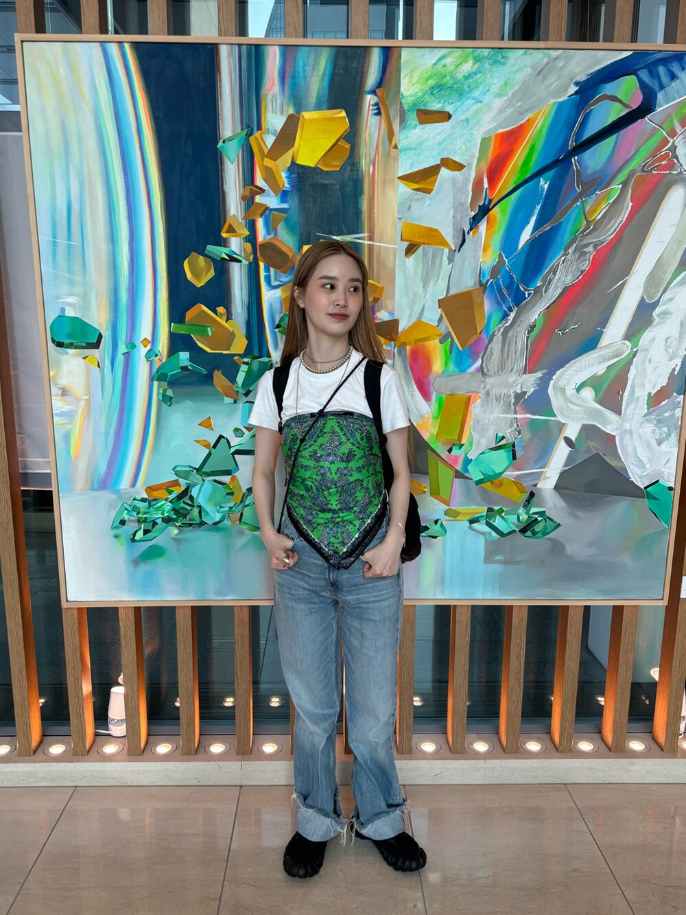 ブルー系のデニムパンツ、ブラック系のスニーカー、ホワイト系のTシャツ/カットソーを着用したレディースの夏コーディネートの3枚目の写真