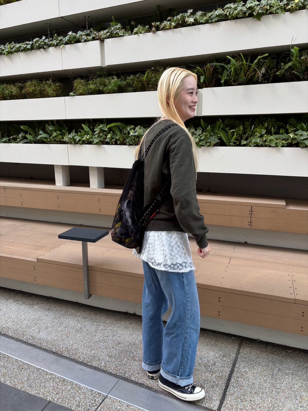 ブルー系のデニムパンツ、ホワイト系のトップス、グリーン系のスウェットを着用したレディースの冬コーディネートの3枚目の写真