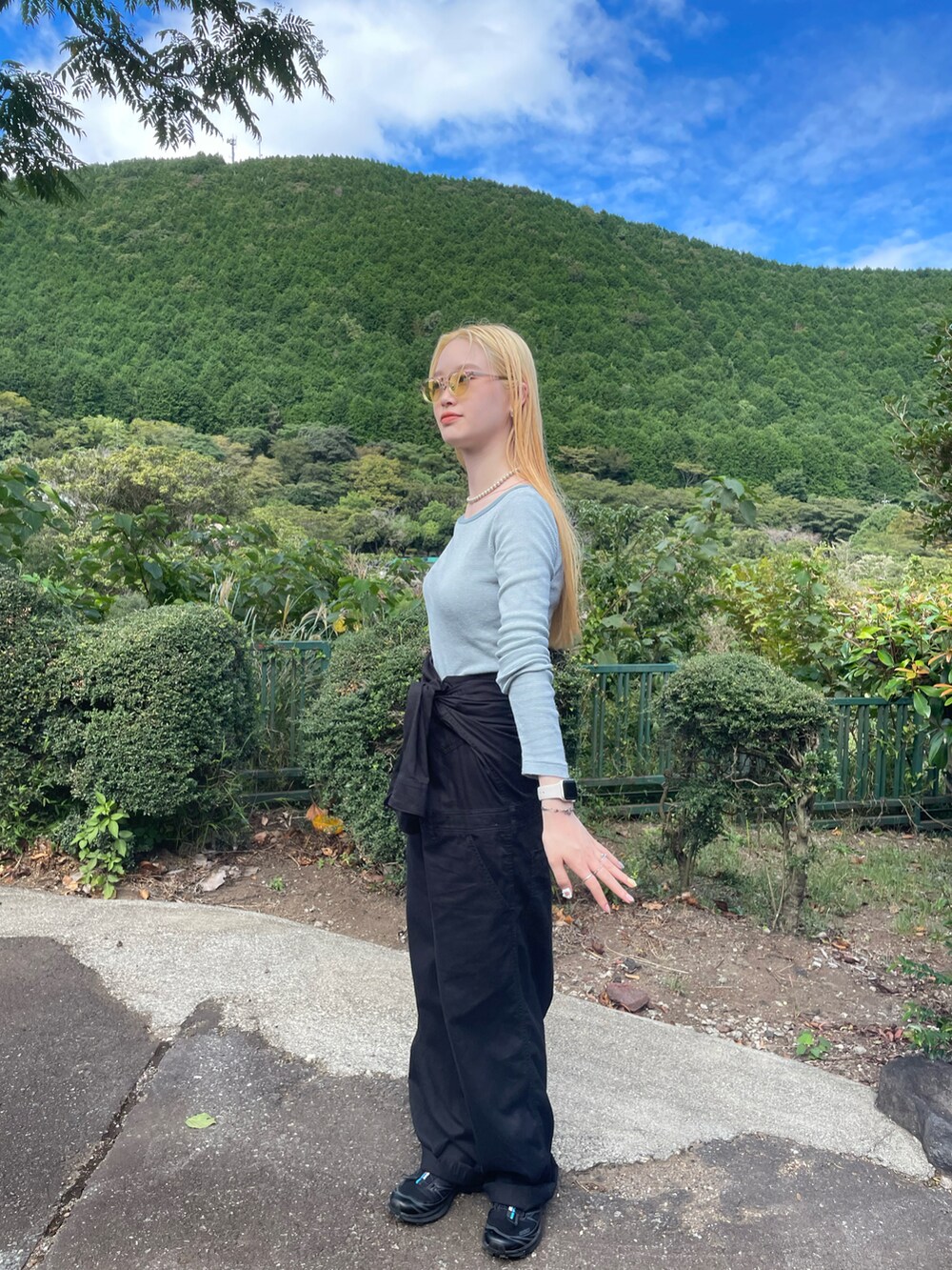 ブルー系のTシャツ/カットソー、ブラック系のつなぎ/オールインワン、ブラック系のスニーカーを着用したレディースの秋コーディネートの2枚目の写真