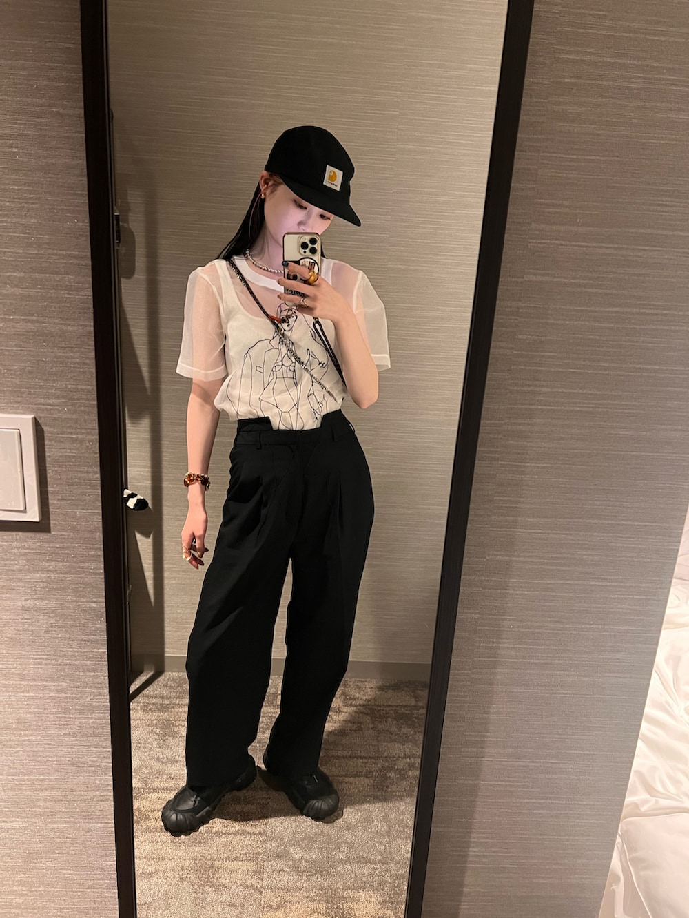 ブラック系のスニーカー、ホワイト系のトップス、ブラック系のキャップを着用したレディースの夏コーディネートの2枚目の写真