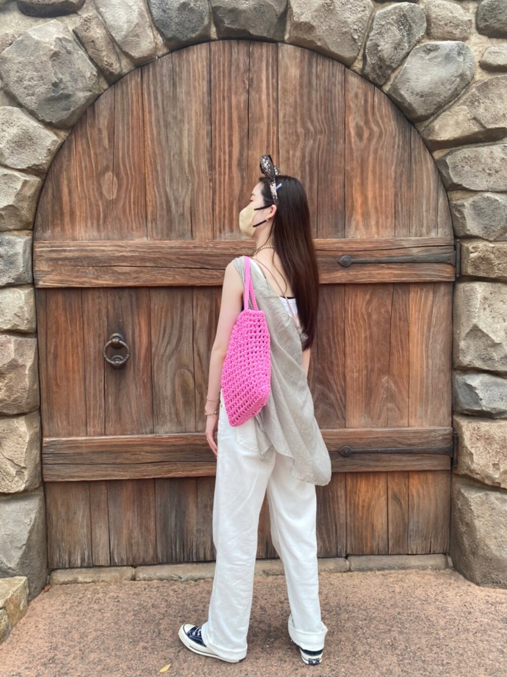 ホワイト系のオールインワン・サロペット、ピンク系のバッグを着用したレディースの夏コーディネートの3枚目の写真