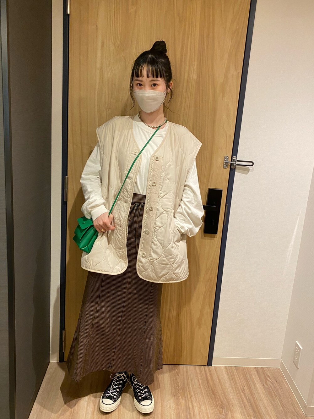 ブラウン系のスカート、ベージュ系のノーカラージャケットを着用したレディースの春コーディネートの2枚目の写真
