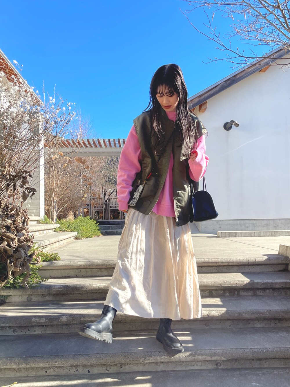 グリーン系のMA-1、ベージュ系のスカートを着用したレディースの冬コーディネートの2枚目の写真