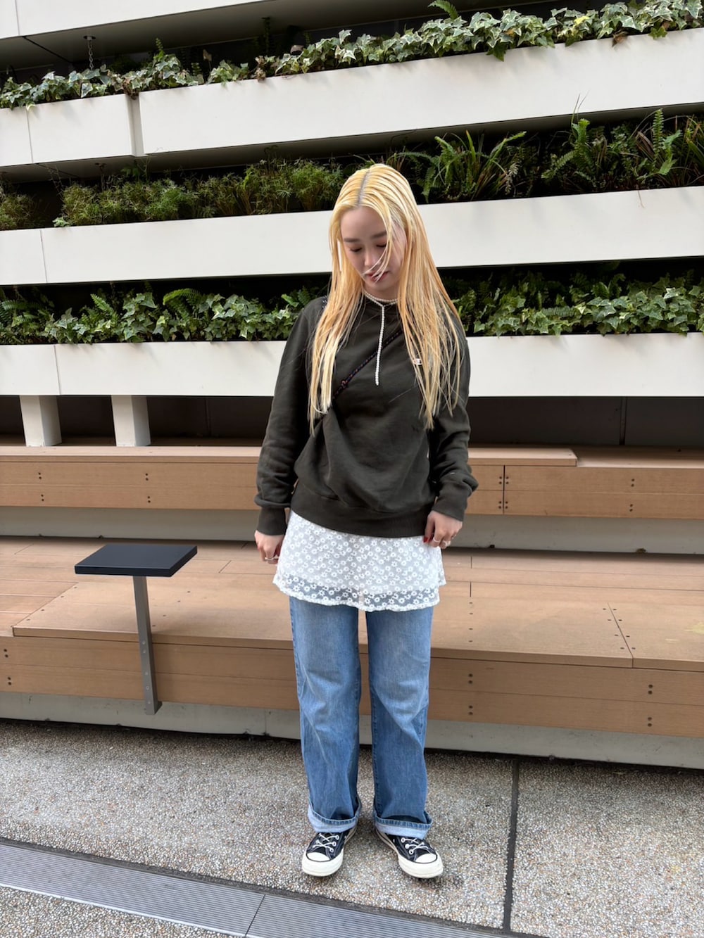 ブルー系のデニムパンツ、ホワイト系のトップス、グリーン系のスウェットを着用したレディースの冬コーディネートの2枚目の写真