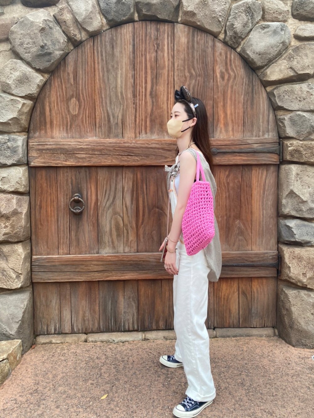 ホワイト系のオールインワン・サロペット、ピンク系のバッグを着用したレディースの夏コーディネートの2枚目の写真