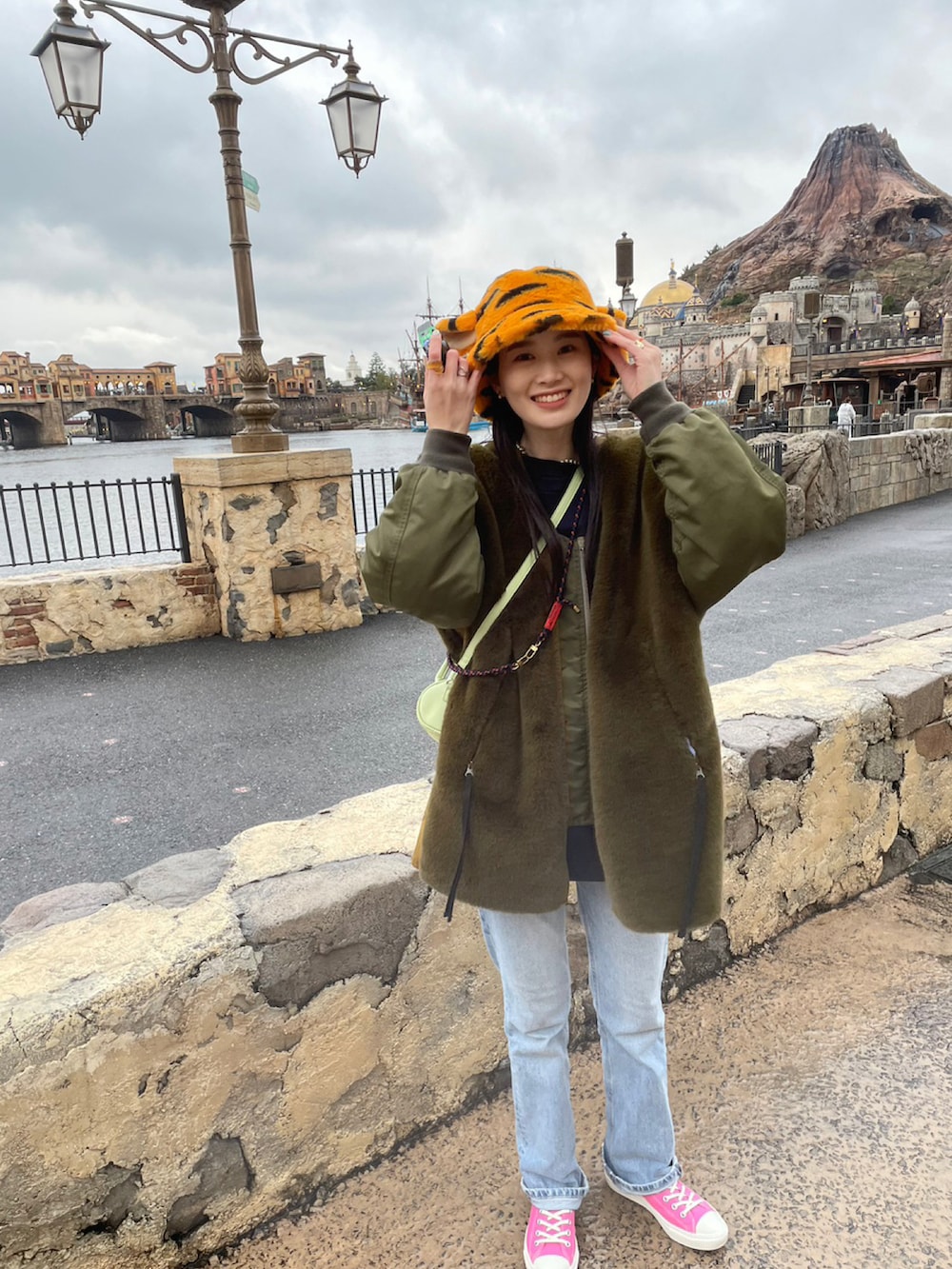 ブルー系のデニムパンツ、ピンク系のスニーカーを着用したレディースの冬コーディネートの2枚目の写真