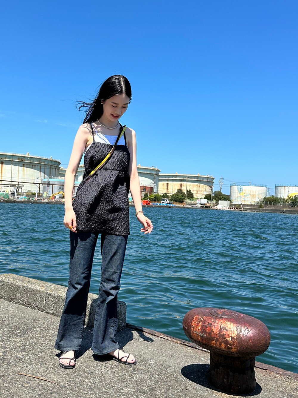 ブラック系のキャミソール、ブラック系のデニムパンツを着用したレディースの夏コーディネートの3枚目の写真