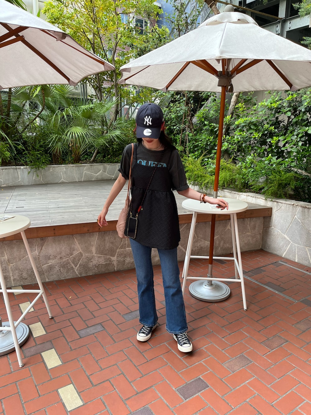 ブラック系のキャミソール、ブルー系のデニムパンツを着用したレディースの夏コーディネートの2枚目の写真