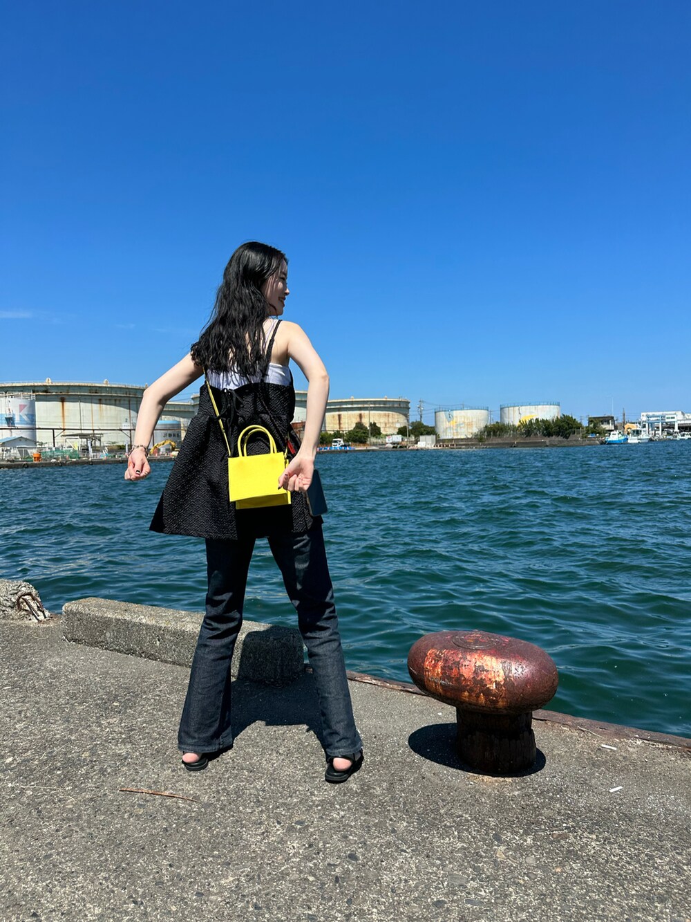 ブラック系のキャミソール、ブラック系のデニムパンツを着用したレディースの夏コーディネートの2枚目の写真