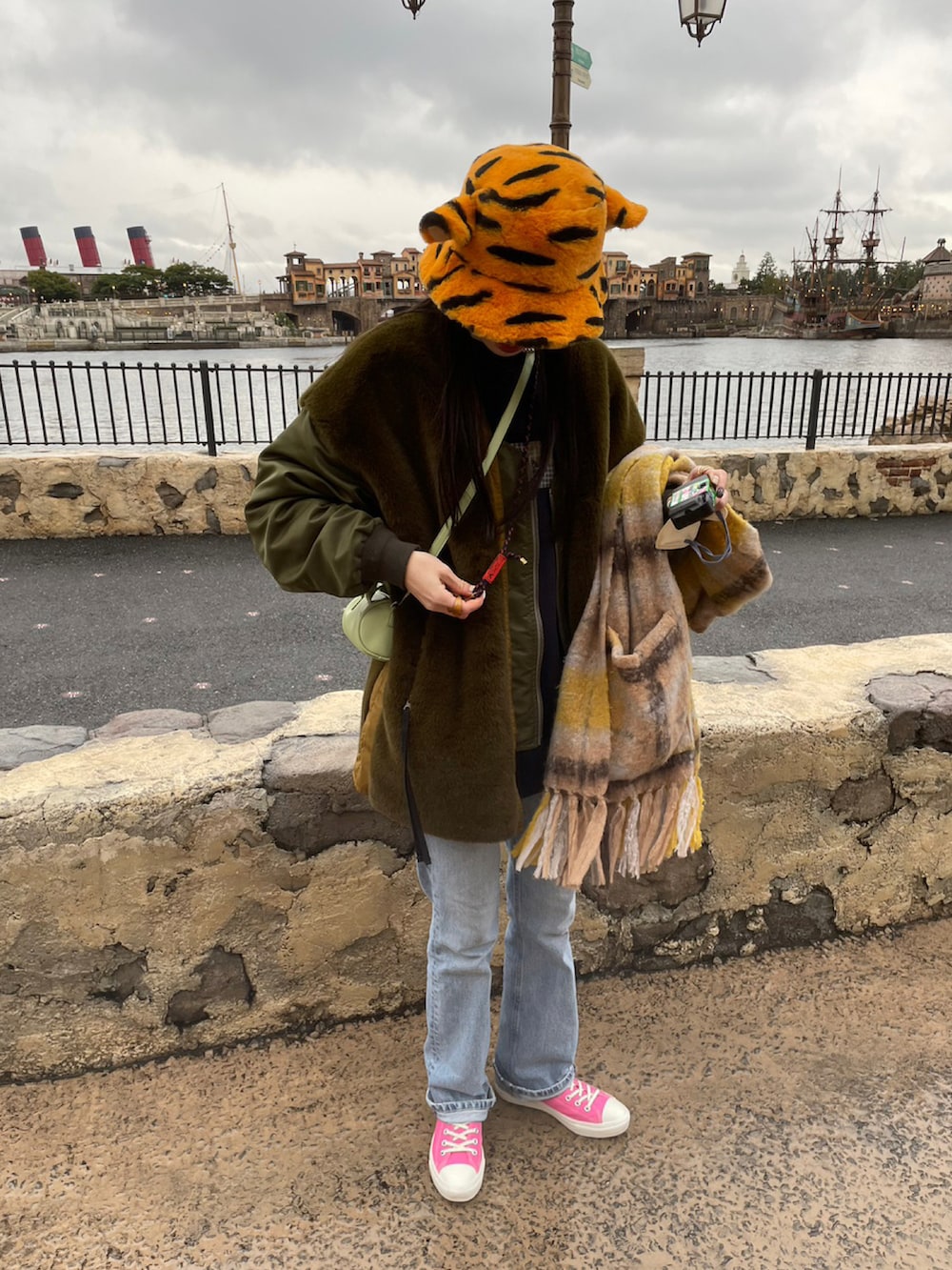 ブルー系のデニムパンツ、ピンク系のスニーカーを着用したレディースの冬コーディネートの3枚目の写真