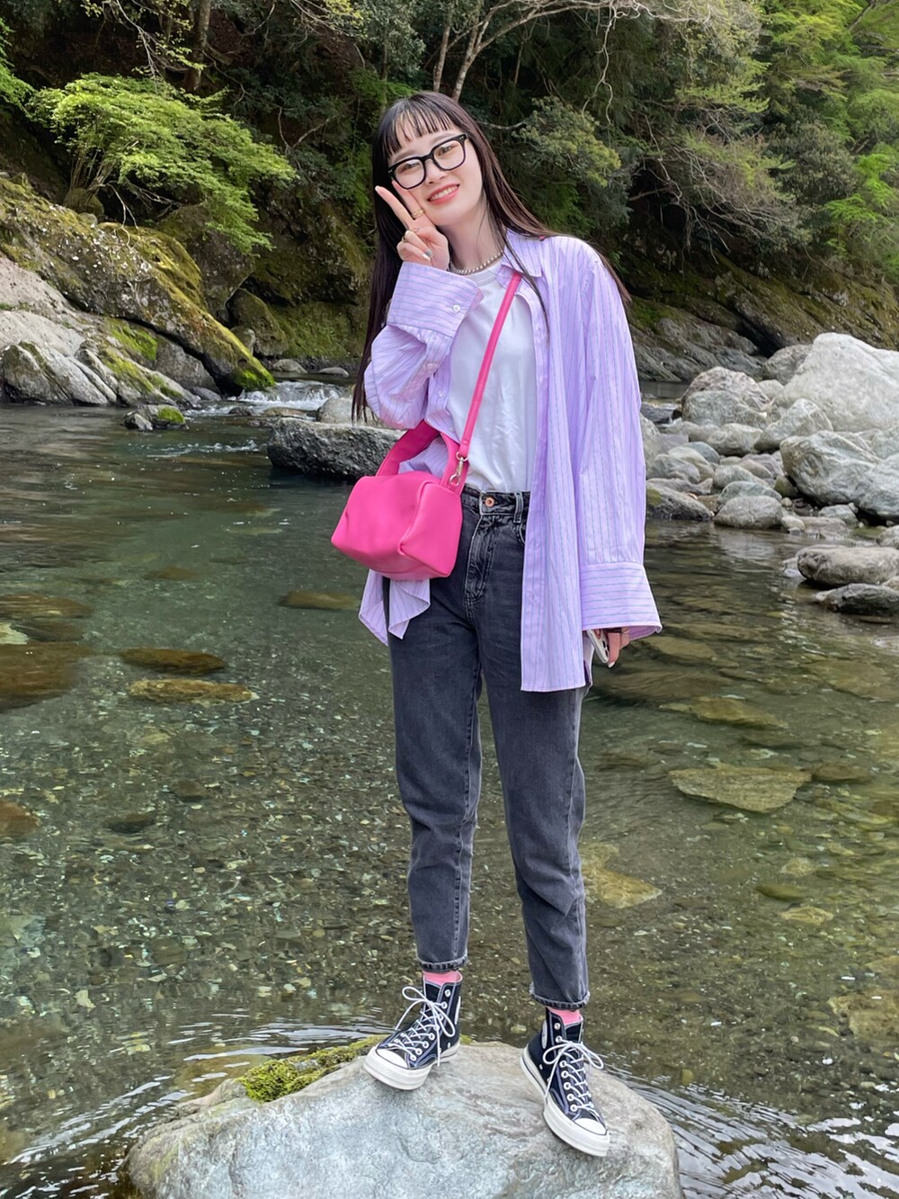 ピンク系のバッグ、ピンク系のシャツ/ブラウス、ブラック系のデニムパンツを着用したレディースの春コーディネートの2枚目の写真