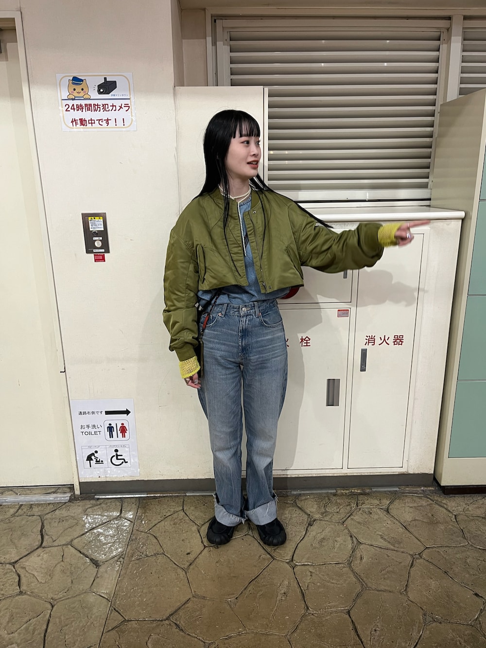 ブルー系のデニムパンツ、ブラック系のスニーカー、イエロー系のTシャツ/カットソーを着用したレディースの冬コーディネートの2枚目の写真